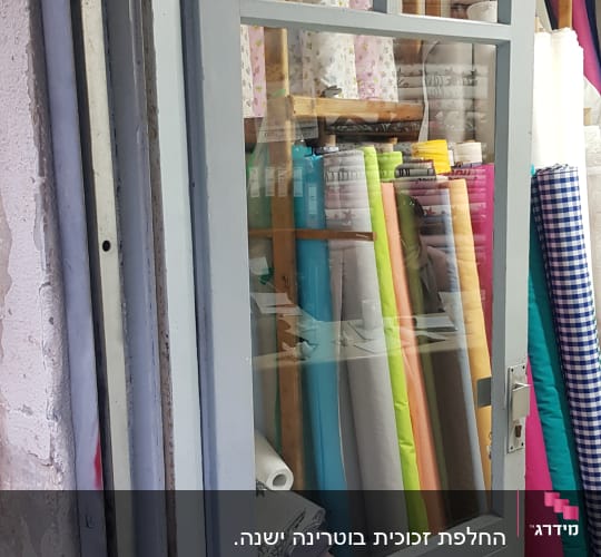 דלת זכוכית עם בדים צבעוניים מאחוריה